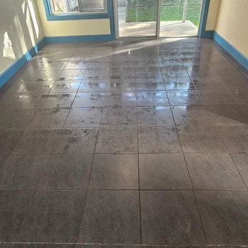 Dark grey floor tiles after cleaning, sliding door behind